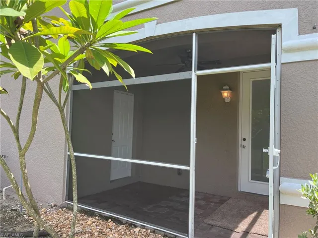 Lanai entrance featuring stucco siding and a sunroom