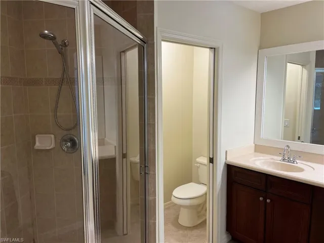 Bathroom featuring vanity, a stall shower, and tile patterned floors