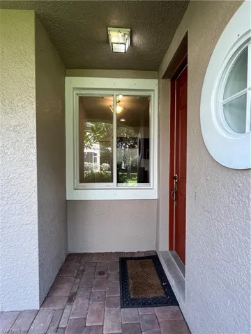 Doorway to property featuring stucco siding and a patio area