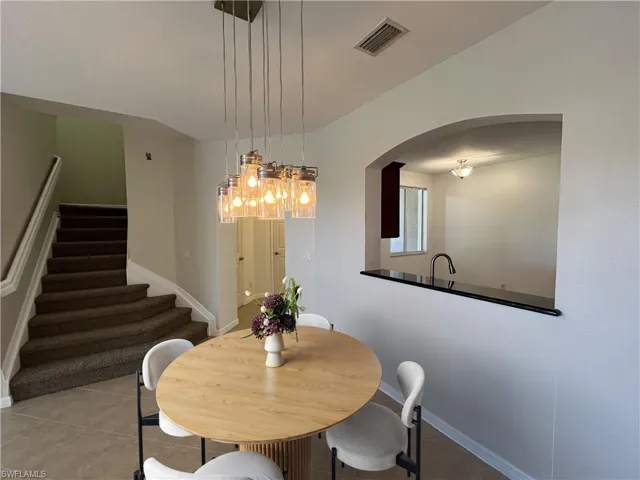 Tiled dining room with stairway