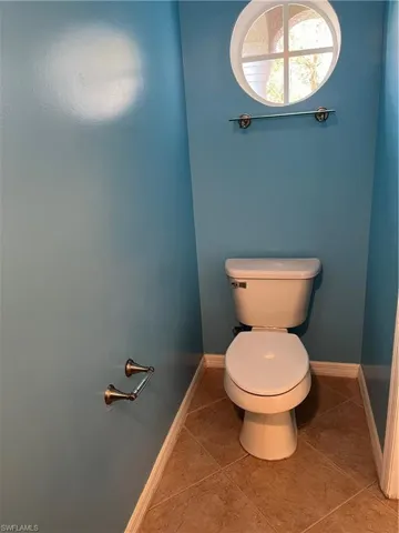 Bathroom with baseboards and light tile patterned floors