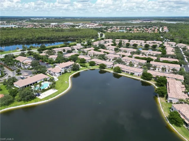 Aerial view of residential area with a large body of water and a tree filled landscape
