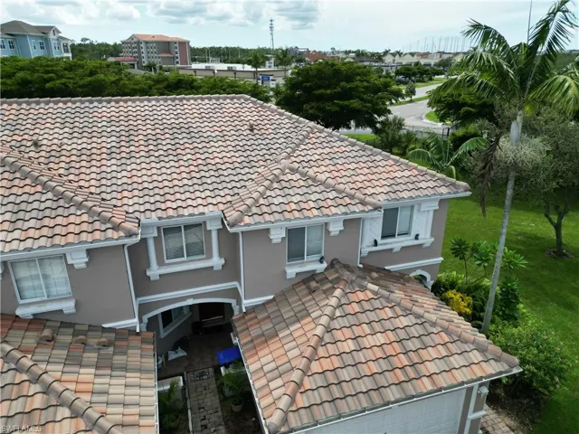 Exterior view of a tiled roof, gutters, a downspout, and stucco siding