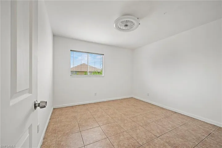 Empty room with light tile patterned floors and baseboards