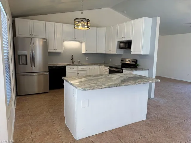 Kitchen featuring freestanding refrigerator, black range, white cabinets, pendant lighting, and stainless steel dishwasher