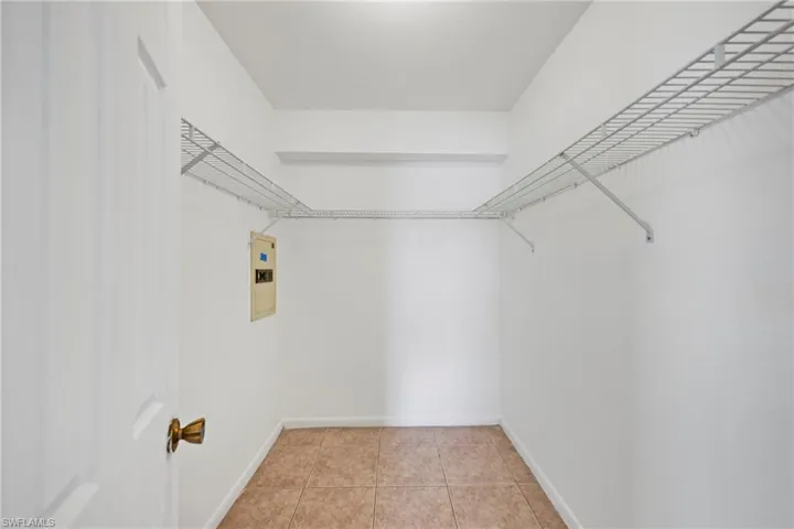 Walk in closet with light tile patterned floors and electric panel