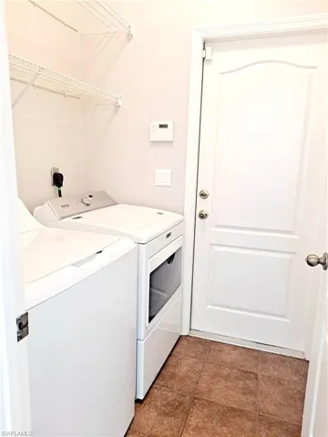 Laundry area featuring washing machine and dryer and light tile patterned floors