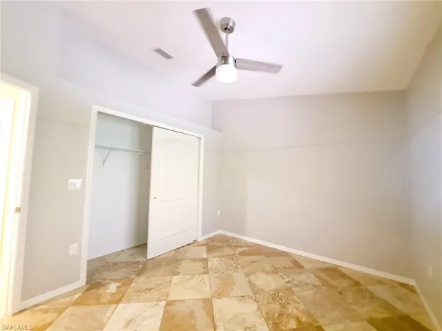 Unfurnished bedroom with a closet, ceiling fan, and lofted ceiling