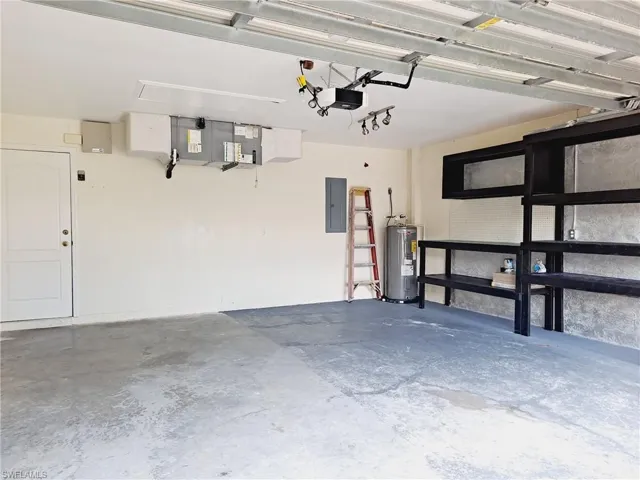 Garage featuring electric panel and water heater