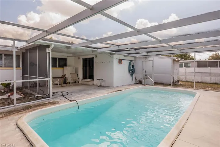 View of swimming pool with a lanai, patio surround, and a sunroom