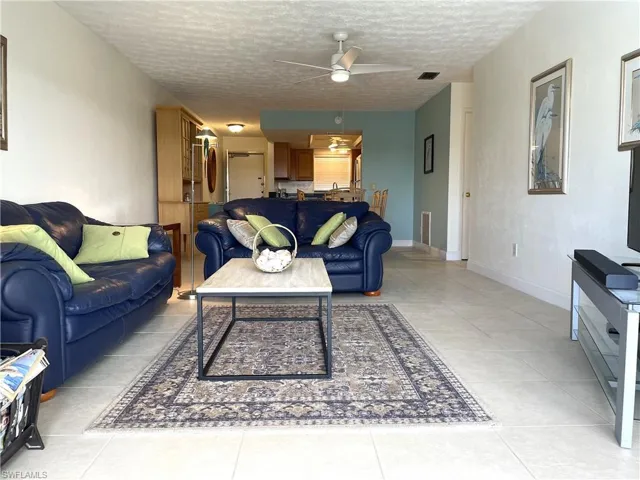 Spacious furnished and tiled living room off the fully pocketed sliders that lead out to the lanai