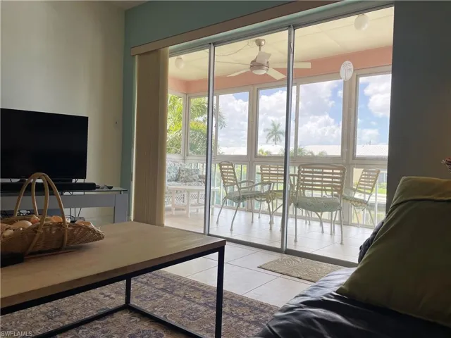 Spacious and furnished tiled living room with views to outside treetops and waterway
