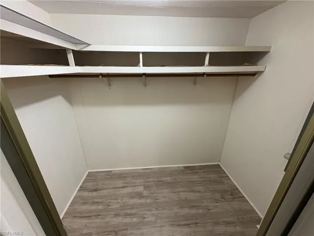 Walk in closet featuring dark wood-style flooring