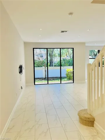 Empty room featuring healthy amount of natural light and light marble finish flooring