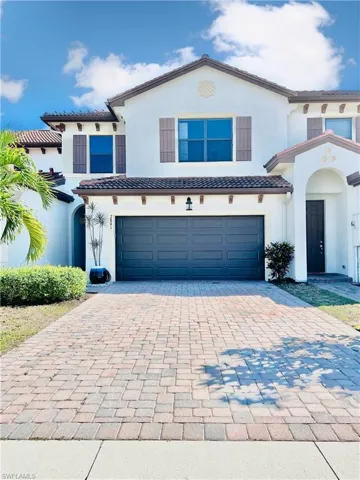 Mediterranean / spanish-style house with an attached garage, stucco siding, decorative driveway, and a tile roof