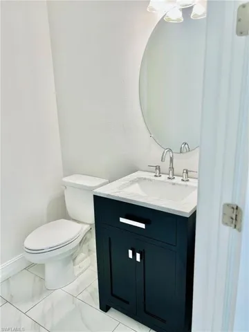 Bathroom with vanity and light marble finish flooring