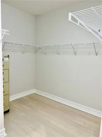 Walk in closet with light wood-style floors