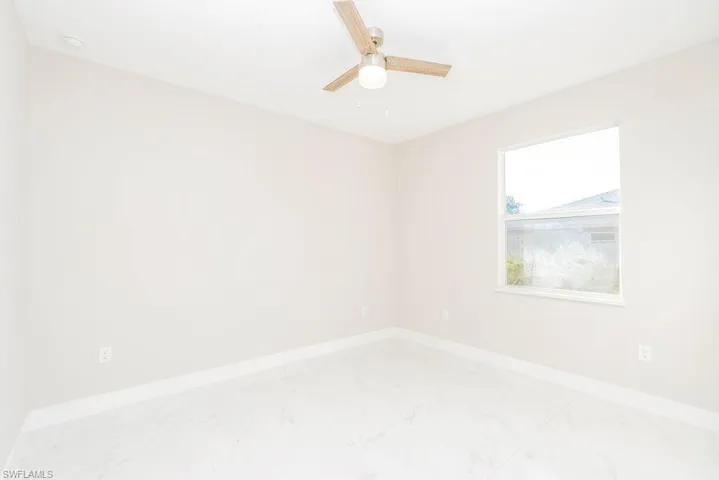 Spare room with marble finish flooring and ceiling fan