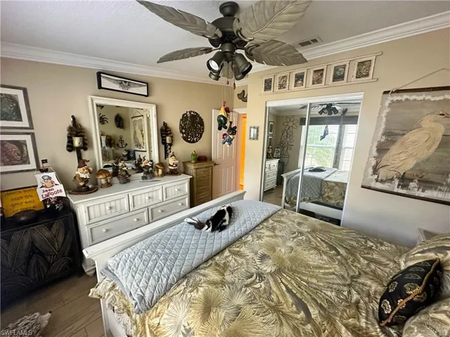 Second Bedroom with ornamental molding, a closet, ceiling fan, and dark hardwood / wood-style floors