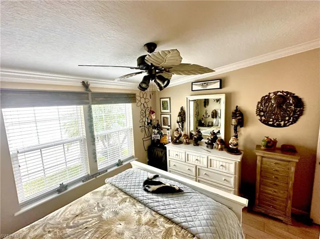 Second Bedroom with ornamental molding, wood-type flooring, ceiling fan, and a textured ceiling