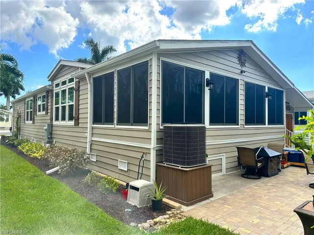 View of side of home featuring AC Heat Pump and a patio area