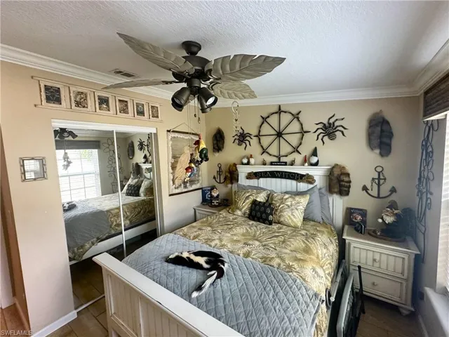 Second Bedroom featuring a textured ceiling, crown molding, ceiling fan, and a closet