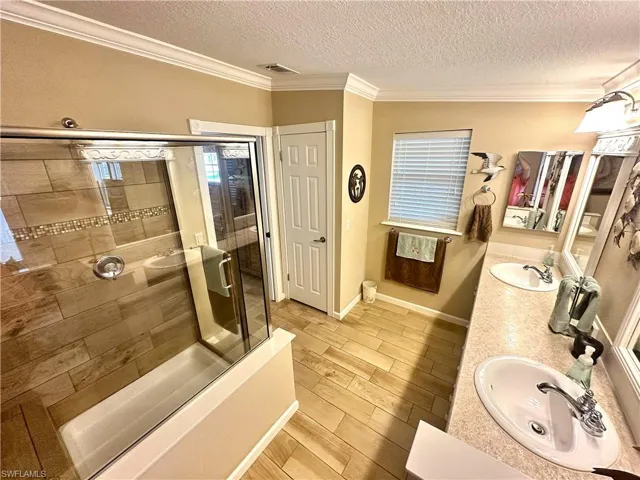 Bathroom with a textured ceiling, independent shower and bath, and vanity
