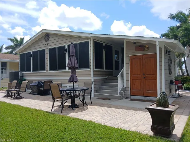 Back of house with a yard and a patio