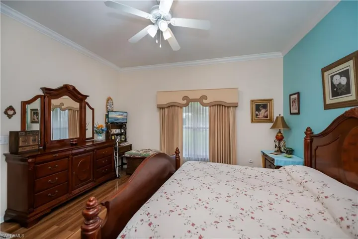 Bedroom featuring crown molding, wood finished floors, and ceiling fan
