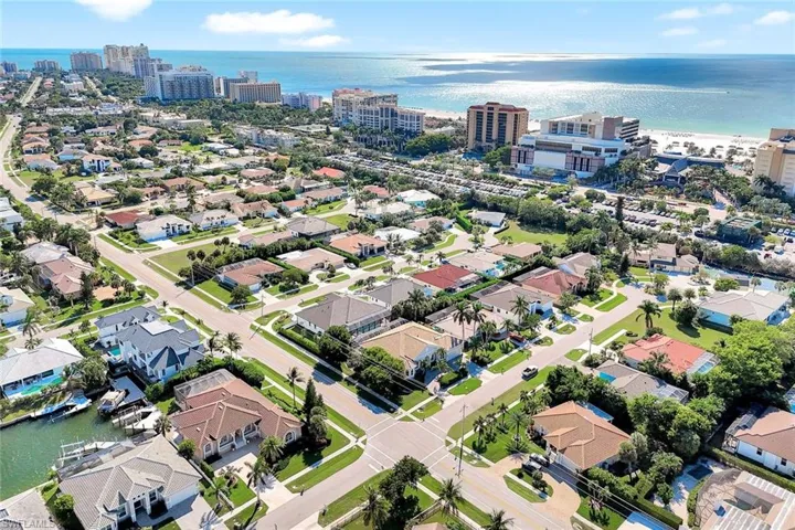 Aerial view of property and surrounding area featuring a nearby body of water and nearby suburban area