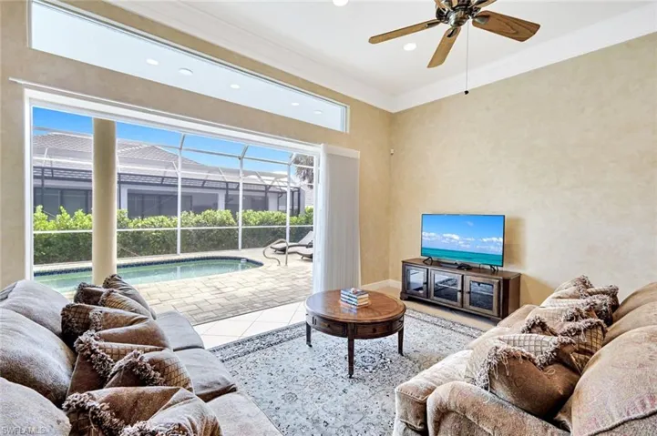 Tiled living room with a sunroom, crown molding, a ceiling fan, and recessed lighting