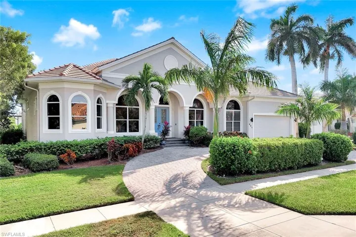 Mediterranean / spanish house with stucco siding, a front yard, and driveway