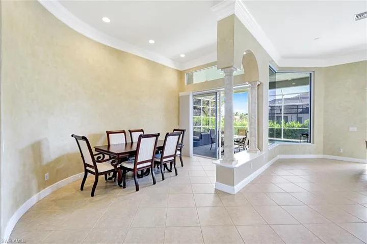 Dining area with crown molding, light tile patterned floors, recessed lighting, and arched walkways