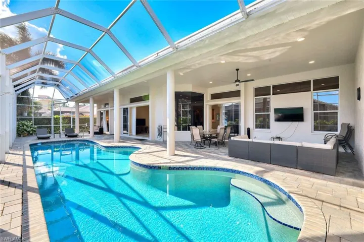 Outdoor pool featuring an outdoor hangout area, a sunroom, a patio, glass enclosure, and a ceiling fan
