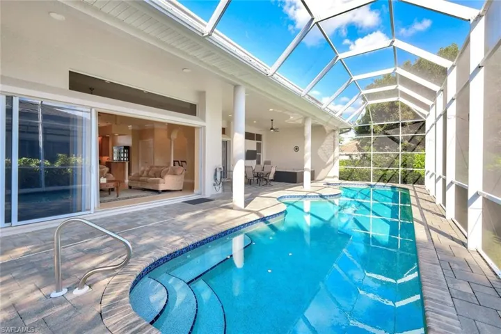 Swimming pool featuring a sunroom, a patio area, glass enclosure, and ceiling fan