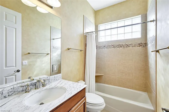 Full bathroom with shower / bathtub combination with curtain and vanity