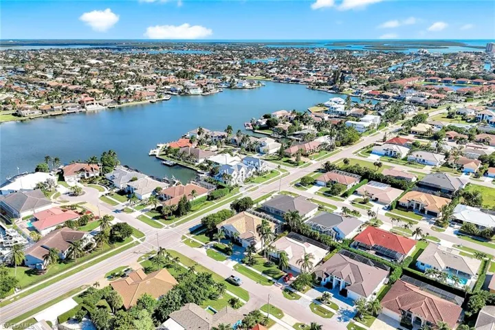 Aerial view of property's location with a nearby body of water and nearby suburban area