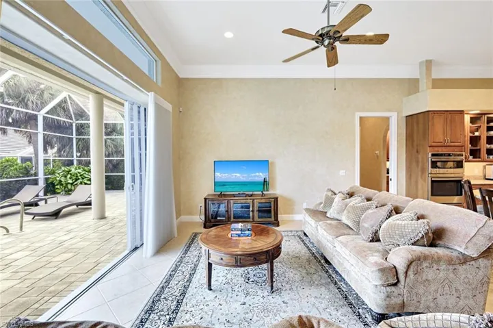 Living area featuring crown molding, light tile patterned flooring, a ceiling fan, and recessed lighting