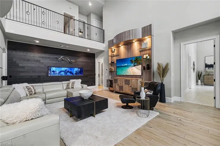 Open-concept living area featuring high ceilings and a second-story overlook with a wrought iron railing