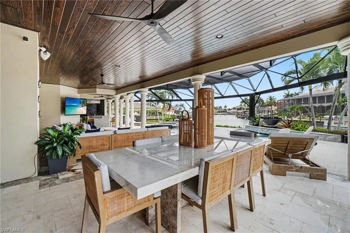 Covered outdoor living space featuring a tongue and groove wood-finish ceiling with recessed lighting and ceiling fans
