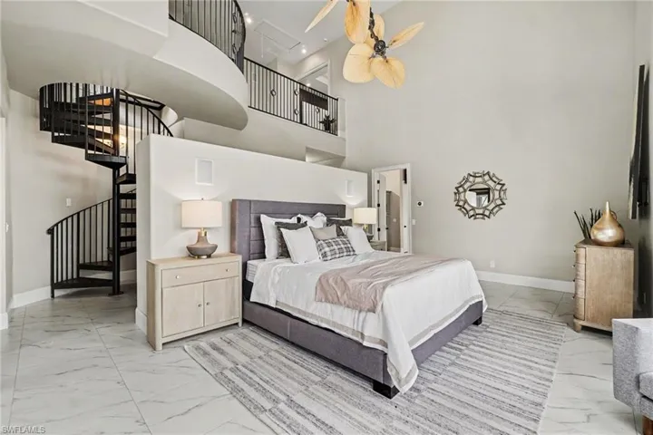 Dramatic interior featuring a multi-level layout with a spiral staircase, iron railings, and high ceilings