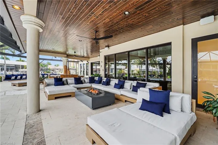 Covered outdoor living area featuring a rich wood-finish ceiling, recessed lighting, and a ceiling fan