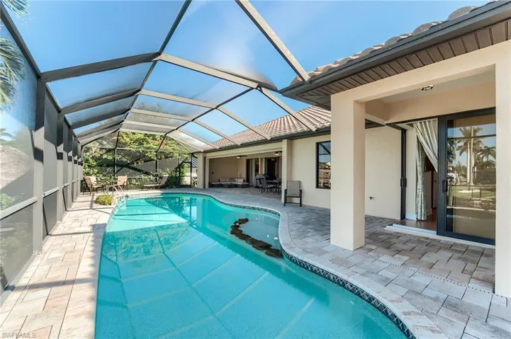 View of pool with ceiling fan, a lanai, and a patio