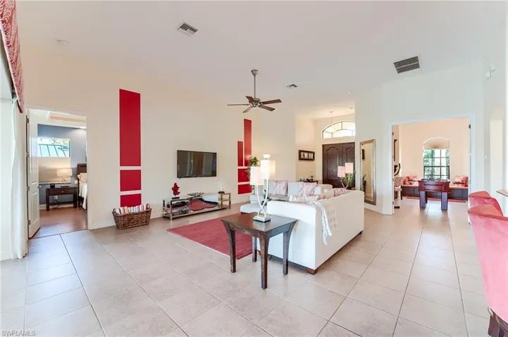Bedroom featuring light hardwood / wood-style flooring, a raised ceiling, ceiling fan, and ornamental molding
