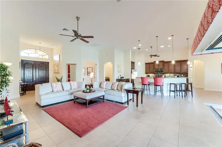 Bedroom featuring ceiling fan, access to exterior, light wood-type flooring, and a tray ceiling