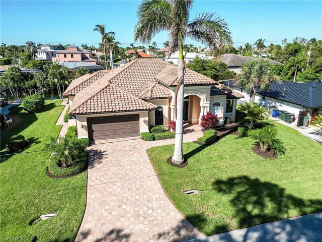 Mediterranean / spanish-style home featuring a front yard and a garage