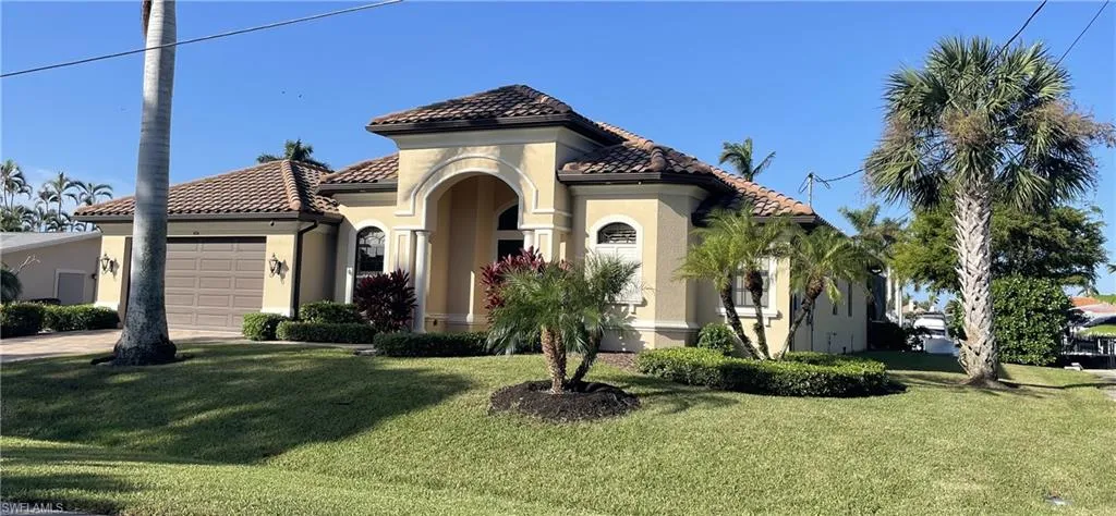 Mediterranean / spanish home with a front yard and a garage