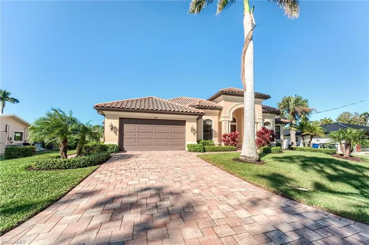 Mediterranean / spanish house with a garage and a front lawn