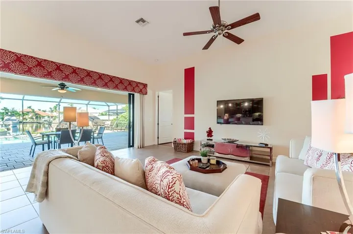Bedroom with ceiling fan, a raised ceiling, light wood-type flooring, and ornamental molding