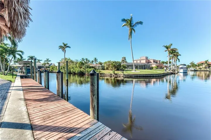 View of dock with a water view and a lawn